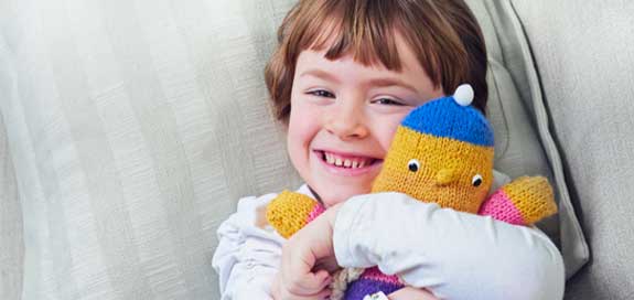 Child hugging toy banner image