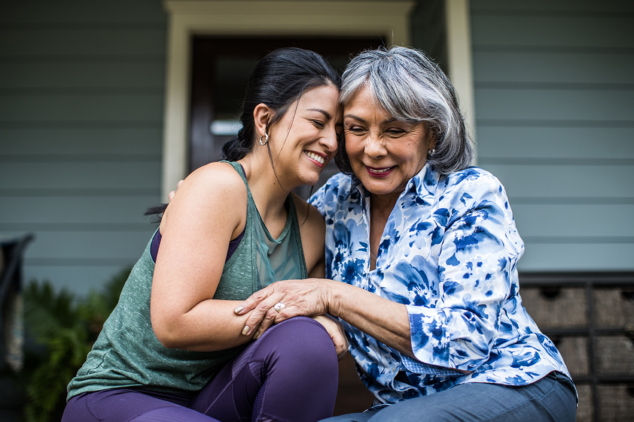 two women hugging on a porch